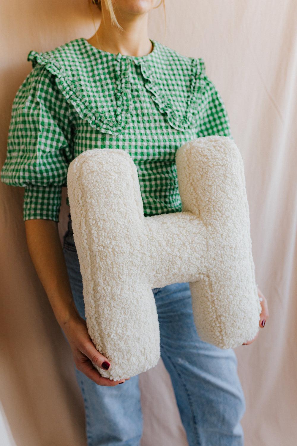 boucle letter cushion H teddy pillow by bettys home held by woman in green shirt twins gift idea