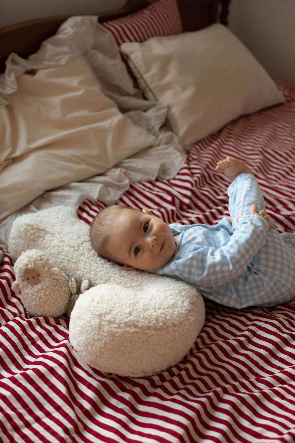 baby boy lying on boucle letter cushion J teddy pillow by bettys home