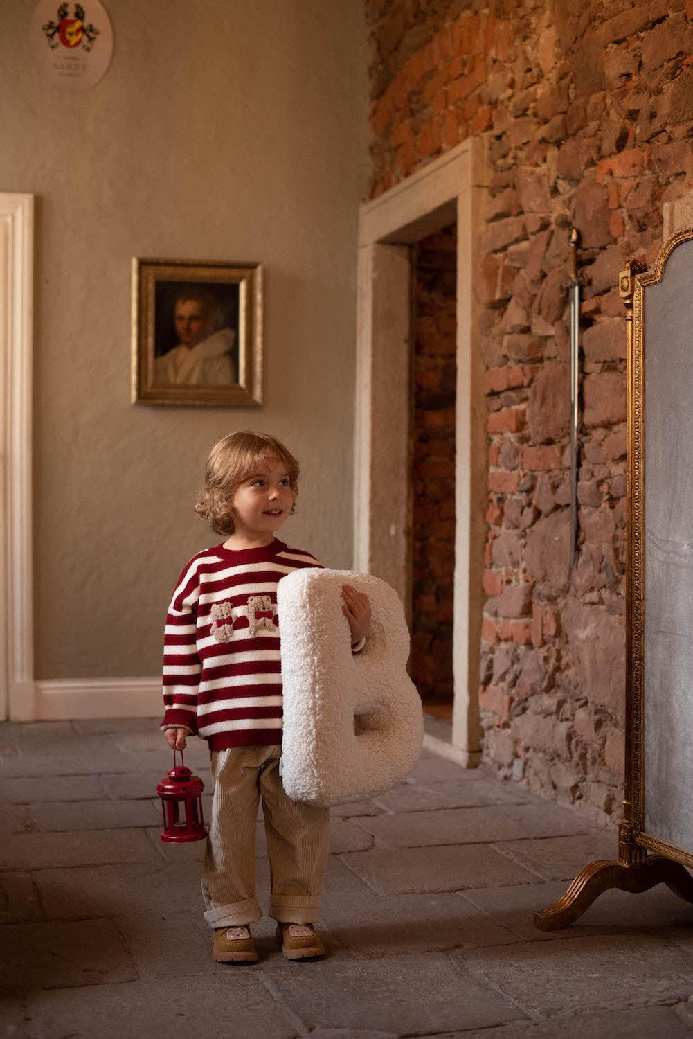boucle letter cushion B teddy pillow by bettys home held by little boy in reed stripe sweater 