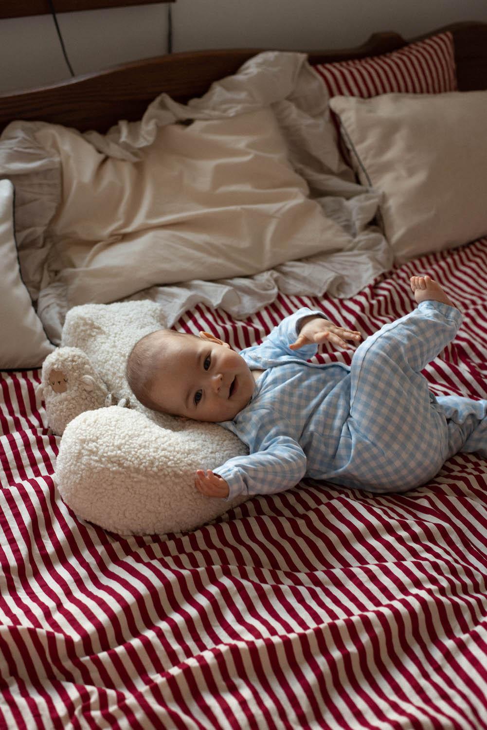 little boy lying on boucle letter cushion J on bed twins gift ideea