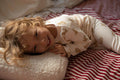little boy lying on boucle letter cushion in his bed 