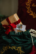 Christmas gift sticking out of an embroidered christmas gift bag in green by bettys home 