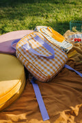 yellow gingham backpack by bettys home who lies on a picnic on a large velvet pouf by bettys home