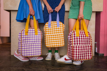 woman with gingham backpacks by bettys home. red gingham backpack and lilac gingham backpack